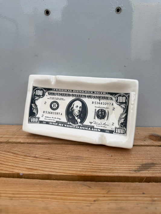 asbak met honderd dollar biljet